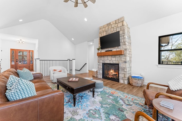 living area with wood finished floors, baseboards, high vaulted ceiling, a fireplace, and recessed lighting