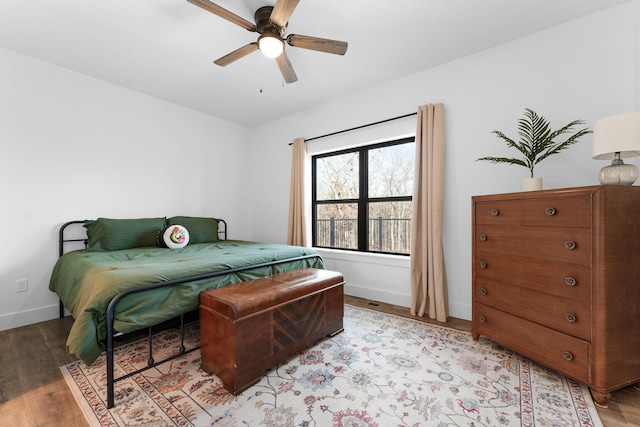 bedroom featuring light wood-style flooring, a ceiling fan, and baseboards