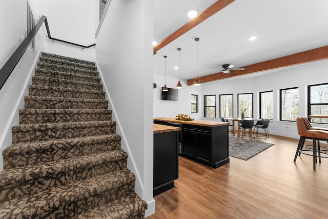 stairway featuring beam ceiling, recessed lighting, wood finished floors, and baseboards