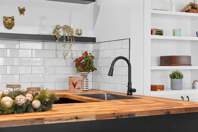 room details with decorative backsplash, open shelves, a sink, and wood counters