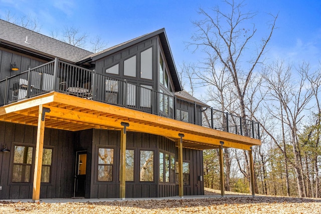 back of property featuring board and batten siding and a shingled roof