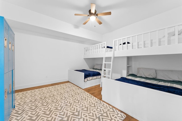 bedroom featuring wood finished floors, baseboards, and ceiling fan