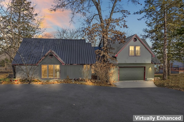 view of front of home featuring a garage, driveway, and metal roof