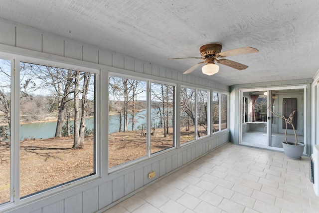 unfurnished sunroom with a water view, plenty of natural light, and ceiling fan