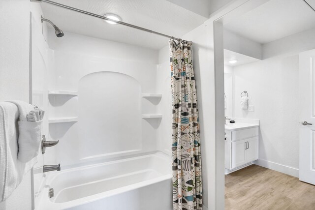 bathroom featuring vanity, shower / tub combo, baseboards, and wood finished floors