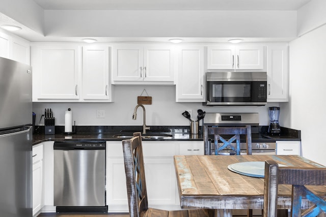 kitchen featuring white cabinets, stainless steel appliances, and a sink