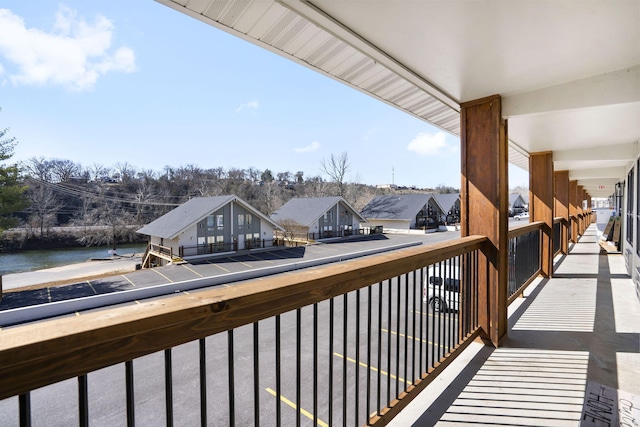 balcony featuring a residential view and a water view