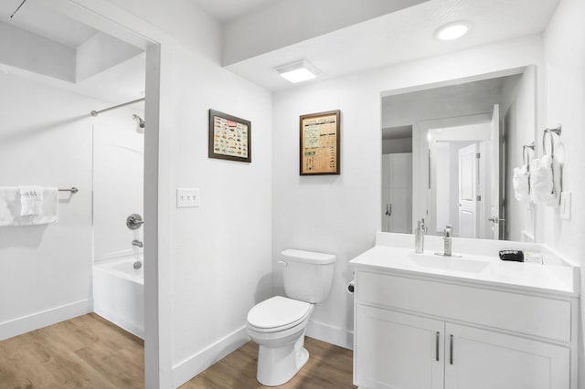 bathroom with bathing tub / shower combination, toilet, wood finished floors, and baseboards