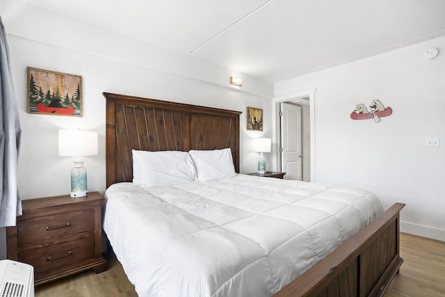 bedroom featuring baseboards and wood finished floors