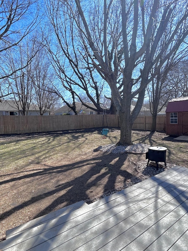 deck featuring an outbuilding, a fenced backyard, and a shed