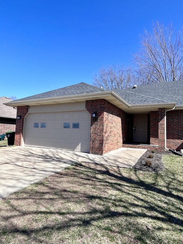 ranch-style home featuring driveway, brick siding, roof with shingles, and an attached garage