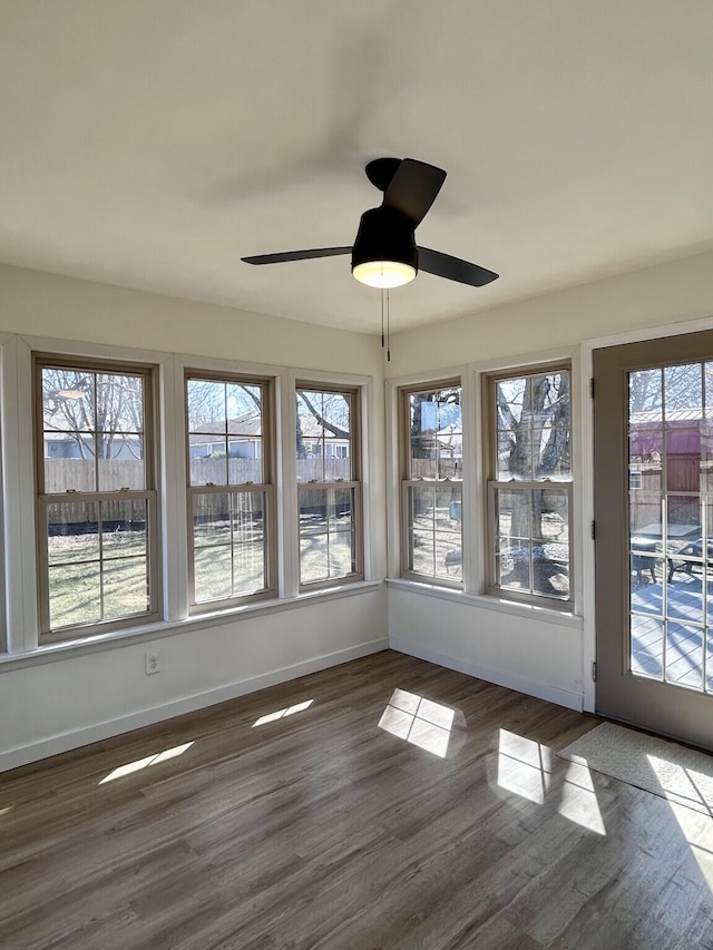 unfurnished sunroom with ceiling fan