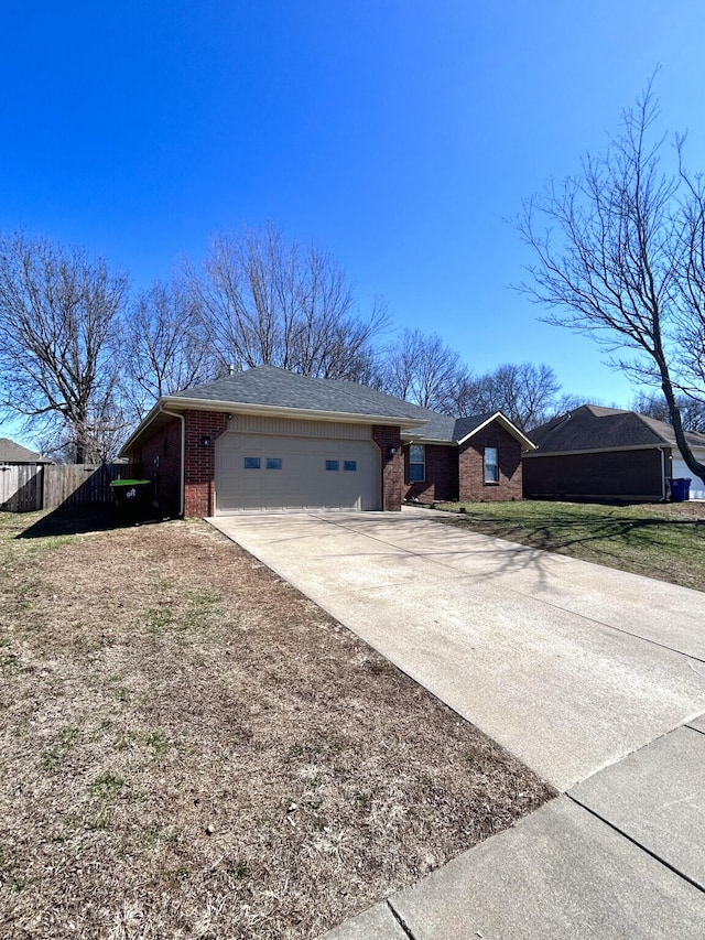 view of front facade with brick siding, an attached garage, a shingled roof, fence, and driveway