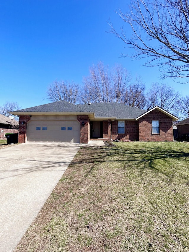 ranch-style home with a shingled roof, concrete driveway, an attached garage, a front yard, and brick siding