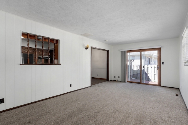 empty room with carpet and a textured ceiling