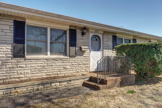 doorway to property featuring brick siding