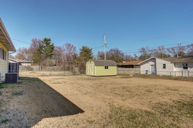 view of yard with an outdoor structure, central air condition unit, a storage unit, and a fenced backyard