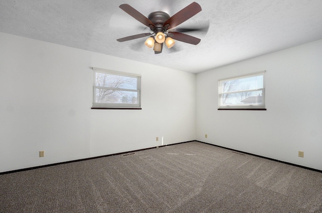 carpeted empty room featuring a textured ceiling, a healthy amount of sunlight, and ceiling fan