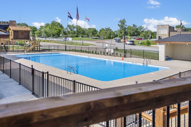 community pool with a patio and fence