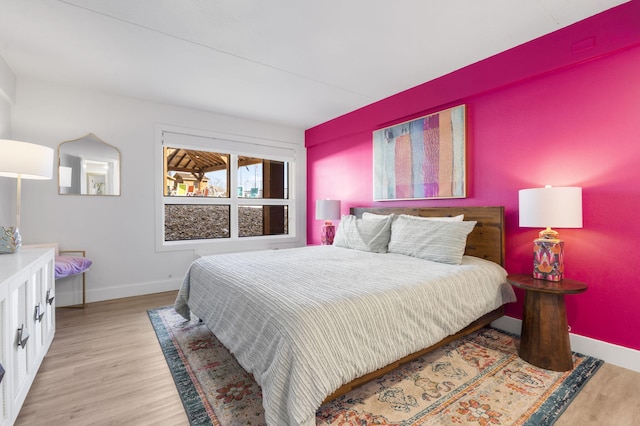 bedroom with light wood finished floors and baseboards
