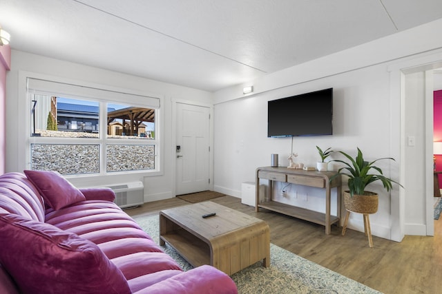 living area with baseboards and wood finished floors