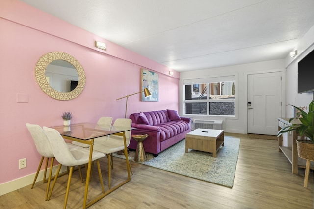 living room featuring radiator, baseboards, and wood finished floors