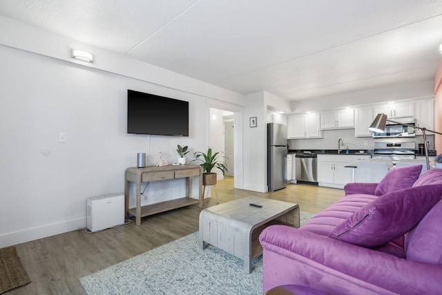 living room with light wood-style flooring and baseboards