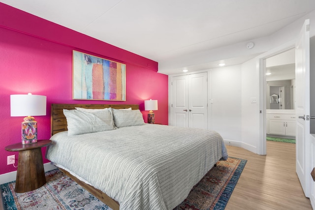 bedroom with recessed lighting, a closet, baseboards, and wood finished floors