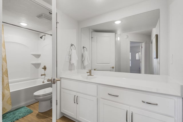 full bath with vanity, wood finished floors, recessed lighting, shower / tub combo, and toilet