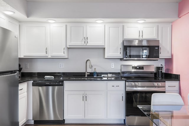 kitchen with a sink, appliances with stainless steel finishes, and white cabinetry