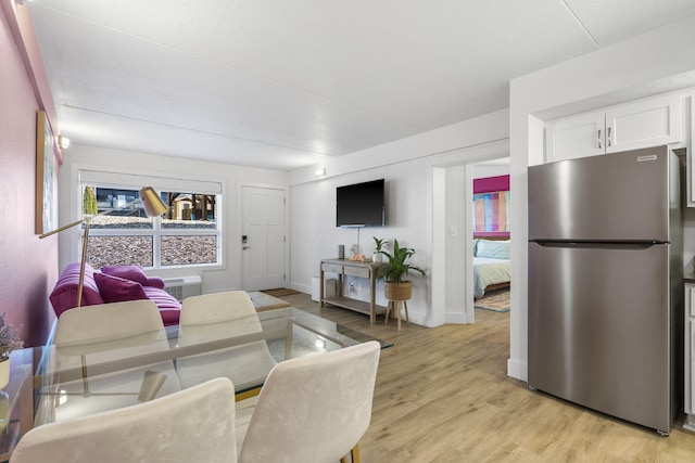 living area featuring light wood-style flooring and baseboards