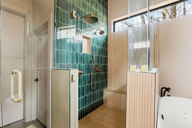 bathroom featuring a bathing tub and a tile shower