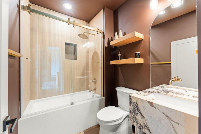 bathroom featuring vanity, toilet, and shower / bath combination with glass door