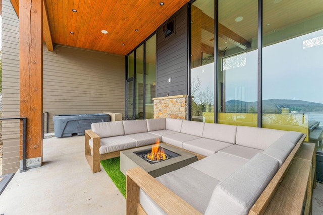 view of patio / terrace featuring an outdoor living space with a fire pit and a hot tub