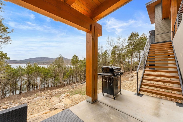 view of patio featuring stairway, a water and mountain view, and grilling area