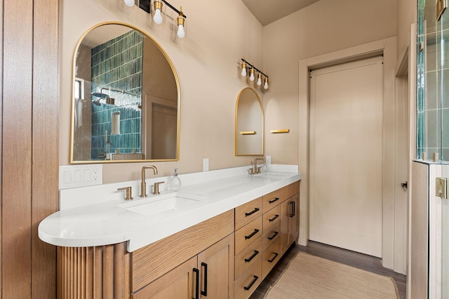 bathroom featuring double vanity, wood finished floors, and a sink