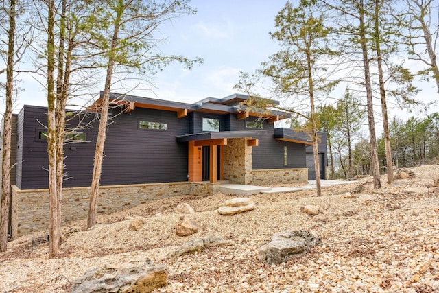 contemporary home featuring stone siding