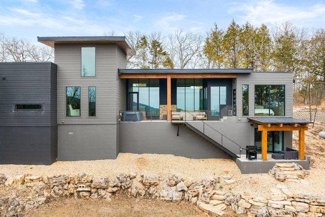 rear view of house with stairs and a sunroom