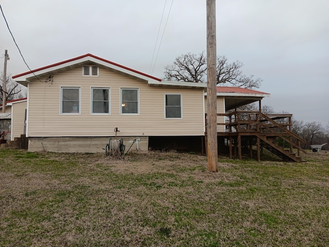 rear view of property with stairway, a lawn, and a deck