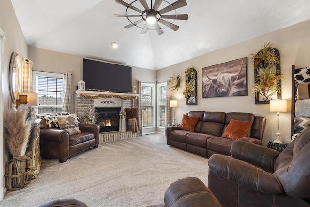 living area with vaulted ceiling, carpet flooring, a fireplace, and ceiling fan