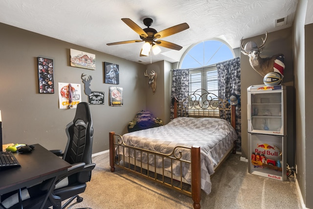 bedroom featuring visible vents, baseboards, carpet flooring, a textured ceiling, and a ceiling fan