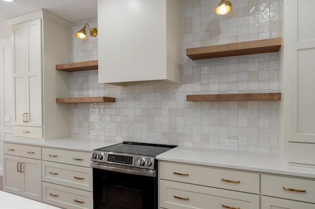 kitchen featuring decorative backsplash, open shelves, light stone countertops, and stainless steel range with electric cooktop