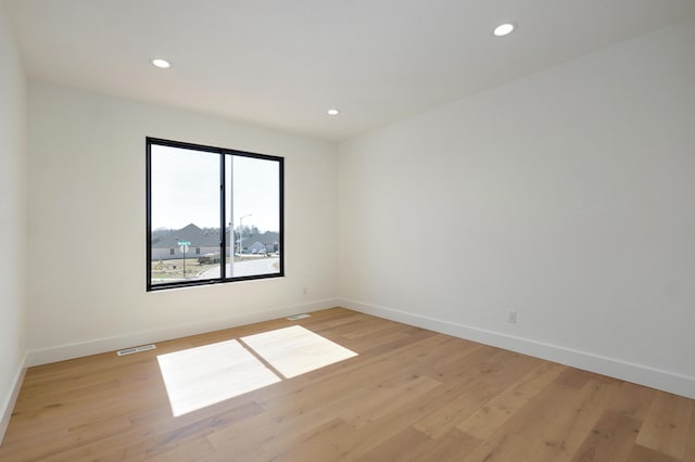 empty room with light wood-type flooring, visible vents, baseboards, and recessed lighting