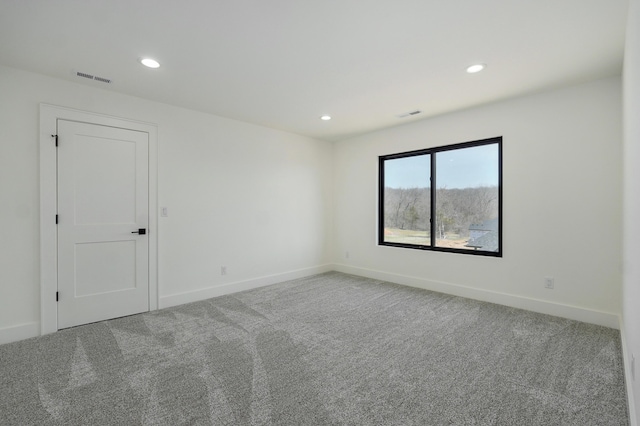 carpeted spare room featuring recessed lighting, visible vents, and baseboards