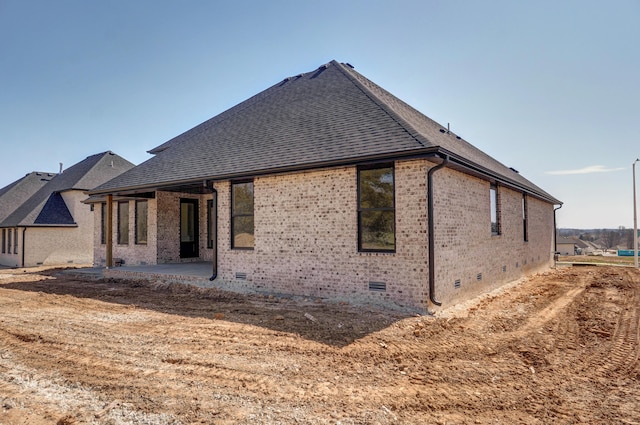 back of property featuring a patio, brick siding, and crawl space