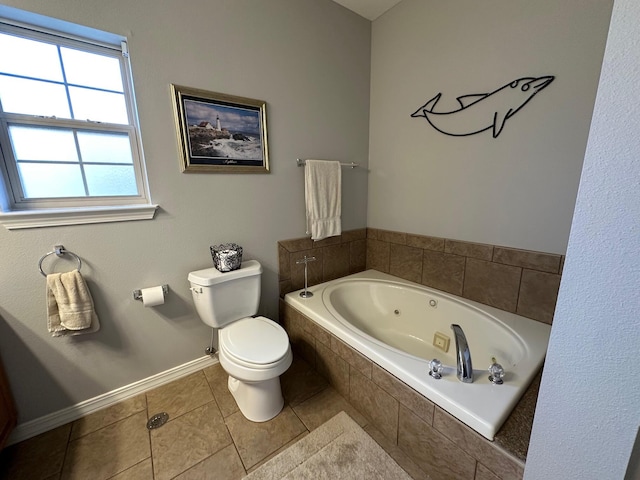 bathroom with baseboards, toilet, a tub with jets, and tile patterned flooring