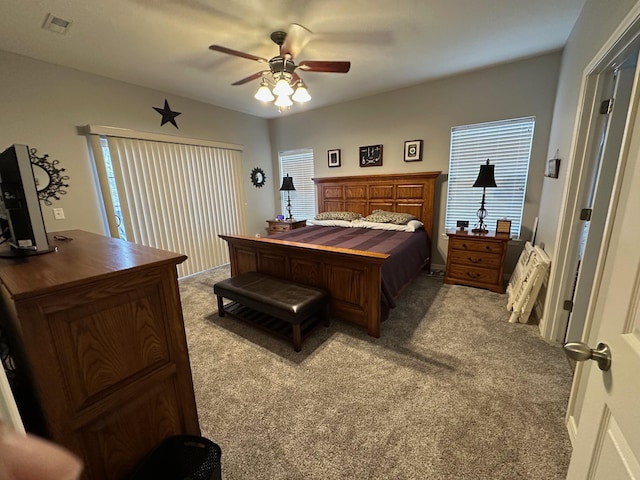 bedroom with multiple windows, a ceiling fan, visible vents, and carpet floors