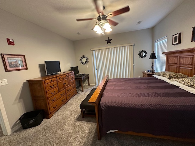 bedroom with visible vents, baseboards, light colored carpet, and ceiling fan