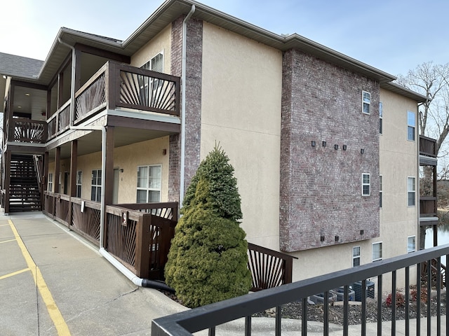 view of side of property featuring brick siding and stucco siding