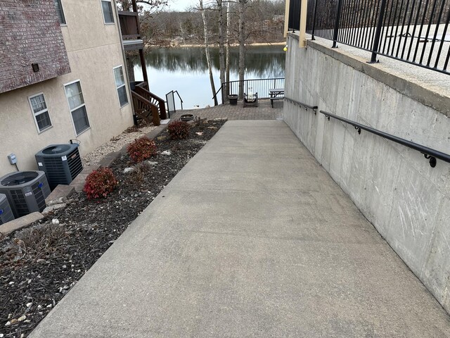 view of patio / terrace featuring central AC unit, a water view, and a boat dock